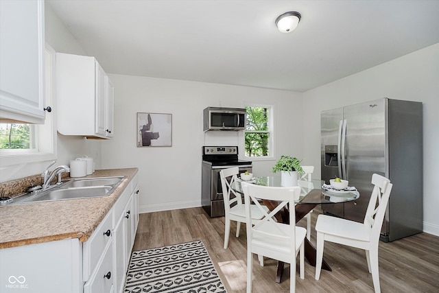 3709 Central Ave, Indianapolis, IN 46205 - kitchen with stainless steel appliances, light wood finished floors, light countertops, and white cabinets
