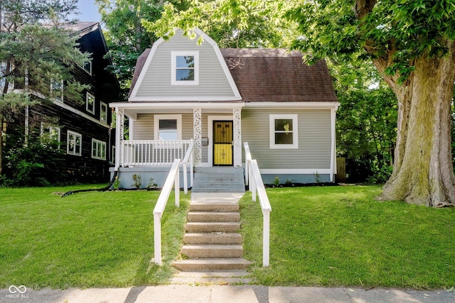 3709 Central Ave, Indianapolis, IN 46205 - dutch colonial featuring a front lawn, a porch, a gambrel roof, and a shingled roof