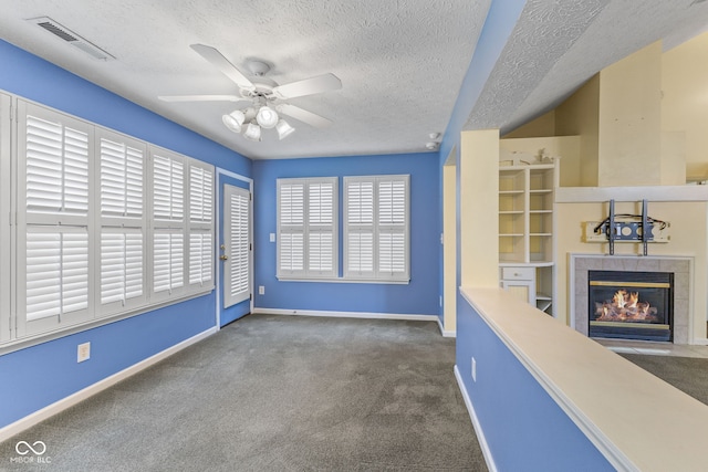 7412 Lattice Dr, Indianapolis, IN 46217 - unfurnished living room with carpet floors, a tile fireplace, a textured ceiling, and ceiling fan