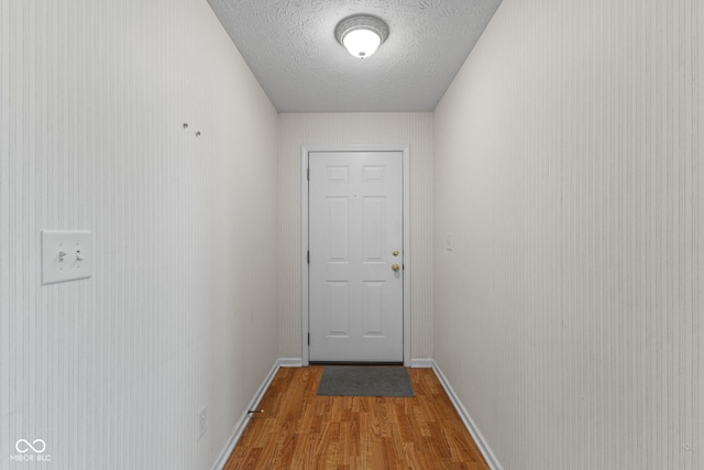 7412 Lattice Dr, Indianapolis, IN 46217 - doorway to outside with light wood finished floors and a textured ceiling