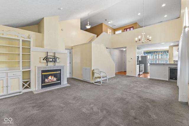 7412 Lattice Dr, Indianapolis, IN 46217 - unfurnished living room featuring a tiled fireplace, carpet, high vaulted ceiling, a chandelier, and wine cooler