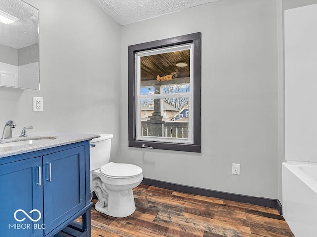 1126 N Rural St, Indianapolis, IN 46201 - full bath with wood finished floors, a textured ceiling, vanity, and a bathtub