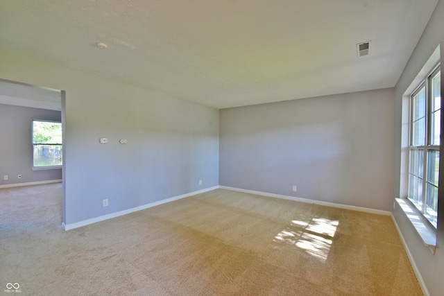5262 Bogey Dr, Indianapolis, IN 46235 - empty room featuring plenty of natural light, light carpet, and a smoke detector