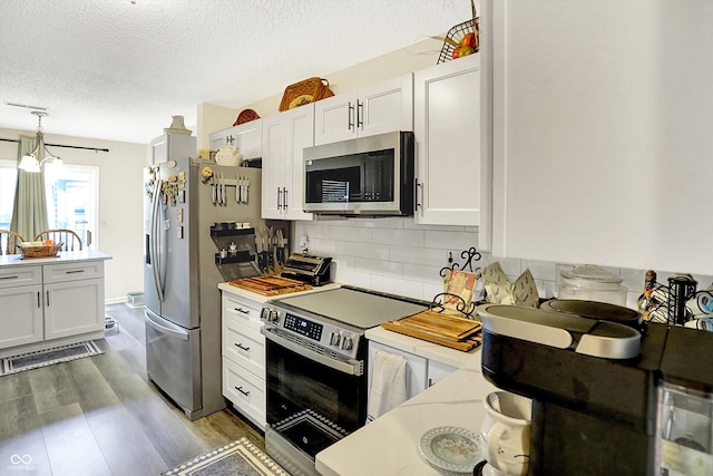 17401 Austrian Pine Way, Westfield, IN 46074 - kitchen with stainless steel appliances, light countertops, backsplash, a textured ceiling, and decorative light fixtures