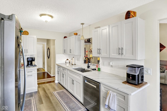 17401 Austrian Pine Way, Westfield, IN 46074 - kitchen with appliances with stainless steel finishes, a textured ceiling, light wood-style flooring, decorative backsplash, and white cabinetry