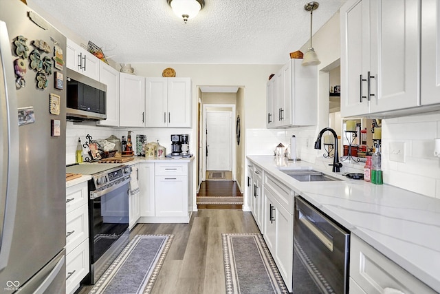 17401 Austrian Pine Way, Westfield, IN 46074 - kitchen with appliances with stainless steel finishes, dark wood-style floors, white cabinets, backsplash, and a textured ceiling