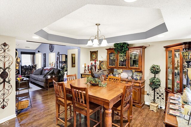 17401 Austrian Pine Way, Westfield, IN 46074 - dining room with a tray ceiling, crown molding, dark wood-style floors, a chandelier, and a textured ceiling