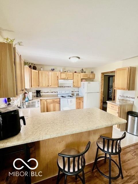 409 N Kyle St, Edinburgh, IN 46124 - kitchen featuring white appliances, light brown cabinets, a peninsula, and light countertops
