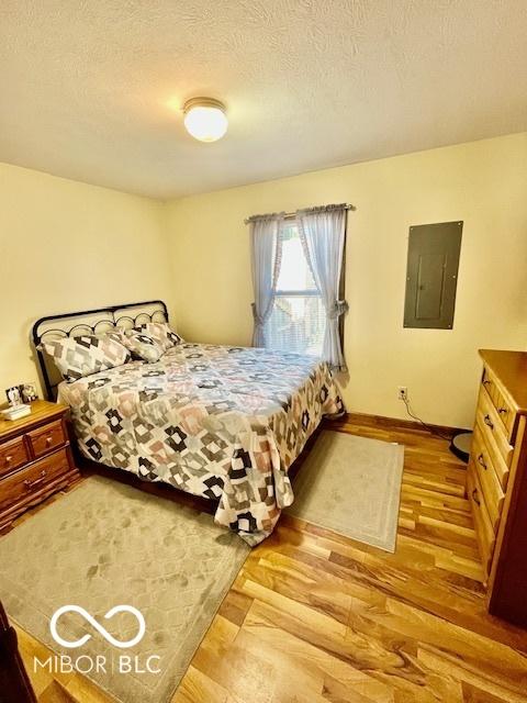 409 N Kyle St, Edinburgh, IN 46124 - bedroom featuring electric panel, wood finished floors, and a textured ceiling