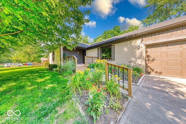 11 N Restin Rd, Greenwood, IN 46142 - view of front of home with brick siding, a front lawn, an attached garage, and concrete driveway