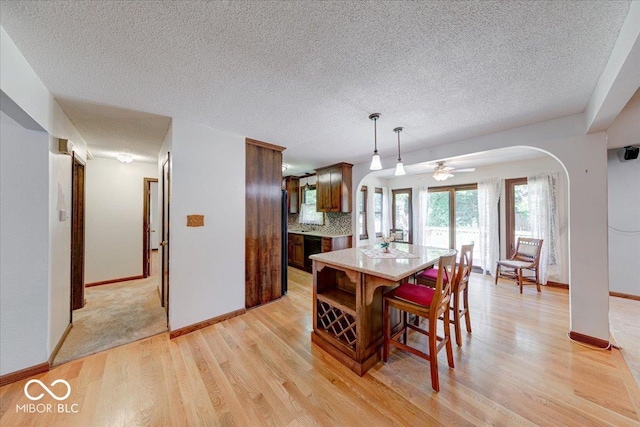 11 N Restin Rd, Greenwood, IN 46142 - dining area with arched walkways, light wood-style flooring, a textured ceiling, and ceiling fan