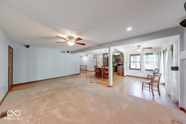 11 N Restin Rd, Greenwood, IN 46142 - carpeted living area with a ceiling fan, arched walkways, a textured ceiling, and wood finished floors