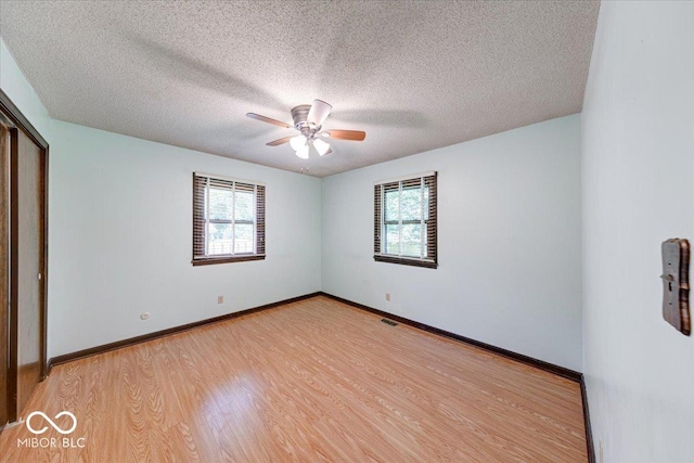 11 N Restin Rd, Greenwood, IN 46142 - unfurnished bedroom featuring multiple windows, light wood-style floors, a textured ceiling, ceiling fan, and a closet