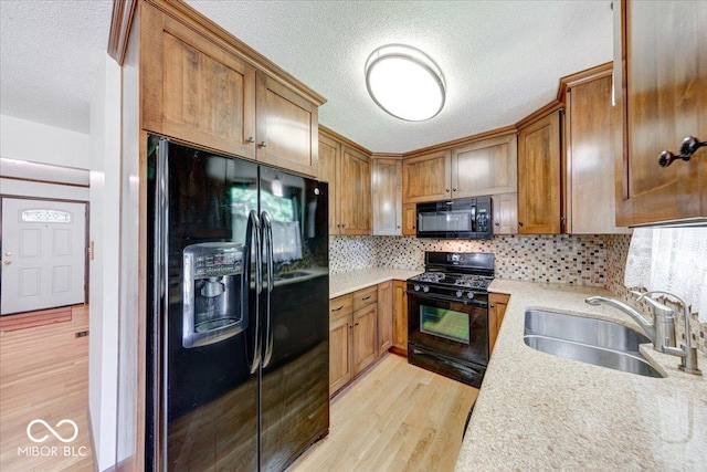 11 N Restin Rd, Greenwood, IN 46142 - kitchen with black appliances, light wood finished floors, a textured ceiling, backsplash, and brown cabinets