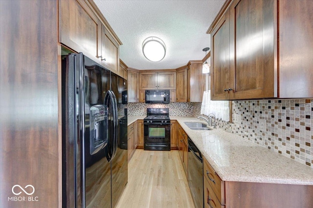 11 N Restin Rd, Greenwood, IN 46142 - kitchen with black appliances, light wood finished floors, a textured ceiling, decorative backsplash, and light stone counters