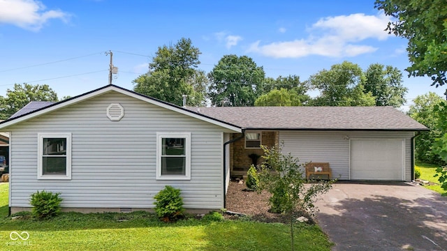 121 Hooton Blvd, Madison, IN 47250 - ranch-style home featuring asphalt driveway, a front yard, an attached garage, and roof with shingles