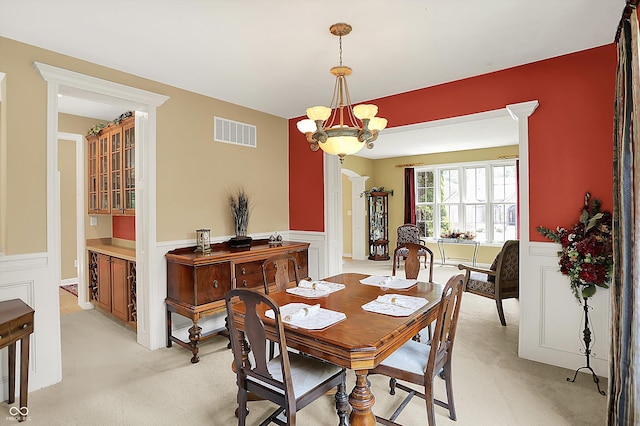 4704 Pearcrest Way, Greenwood, IN 46143 - dining space featuring a wainscoted wall, light colored carpet, and a chandelier