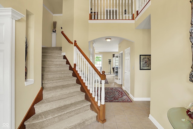 4704 Pearcrest Way, Greenwood, IN 46143 - staircase featuring arched walkways, tile patterned floors, and a towering ceiling
