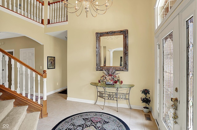 4704 Pearcrest Way, Greenwood, IN 46143 - entryway featuring a towering ceiling, tile patterned flooring, arched walkways, stairs, and a chandelier