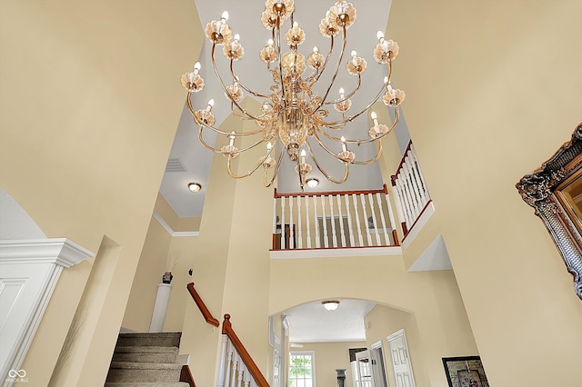 4704 Pearcrest Way, Greenwood, IN 46143 - staircase featuring a towering ceiling, arched walkways, and a chandelier