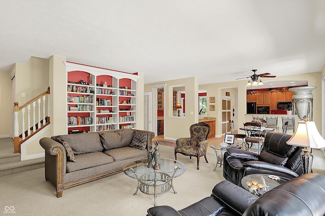 4704 Pearcrest Way, Greenwood, IN 46143 - living area featuring light carpet, a ceiling fan, and stairs