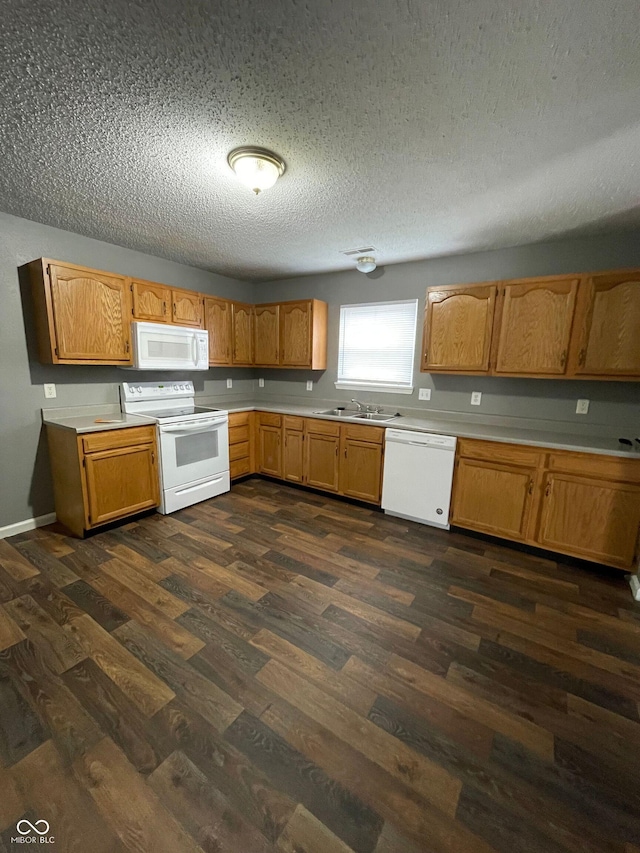 3929 Roundwood Dr, Indianapolis, IN 46235 - kitchen featuring white appliances, light countertops, dark wood-style floors, a textured ceiling, and brown cabinetry