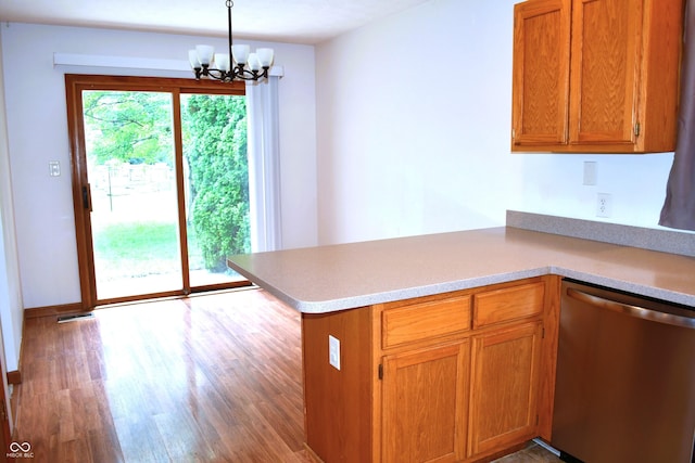 3363 Paddington Dr, Columbus, IN 47203 - kitchen with dishwasher, a chandelier, wood finished floors, light countertops, and brown cabinetry