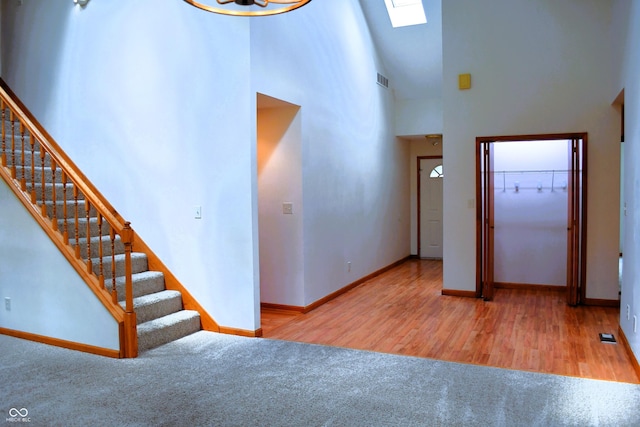3363 Paddington Dr, Columbus, IN 47203 - carpeted foyer entrance featuring a towering ceiling, stairway, a skylight, and wood finished floors