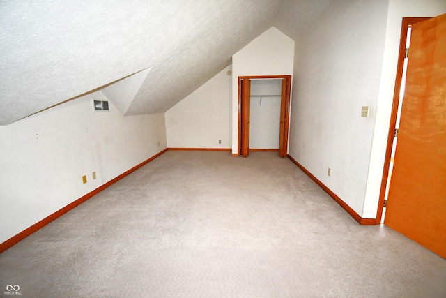 3363 Paddington Dr, Columbus, IN 47203 - additional living space with lofted ceiling, carpet flooring, and a textured ceiling