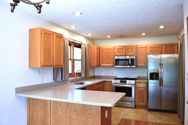 3363 Paddington Dr, Columbus, IN 47203 - kitchen with appliances with stainless steel finishes, a peninsula, light countertops, recessed lighting, and brown cabinets