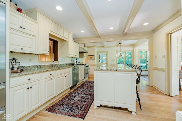 6280 N Chester Ave, Indianapolis, IN 46220 - kitchen featuring under cabinet range hood, light wood-style floors, appliances with stainless steel finishes, beamed ceiling, and light stone counters