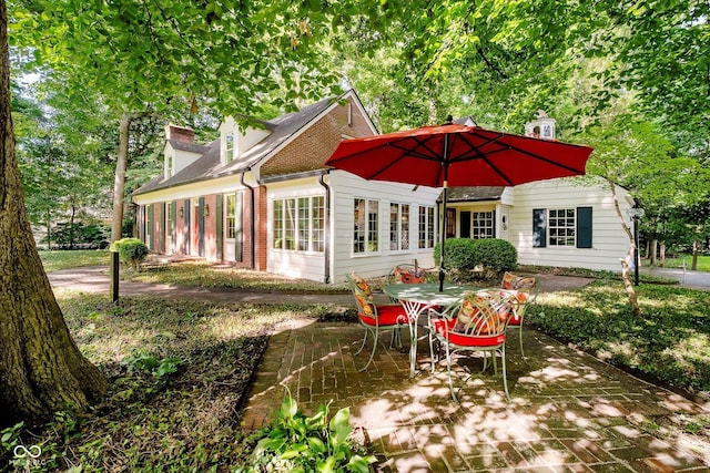 6280 N Chester Ave, Indianapolis, IN 46220 - back of property featuring brick siding, a chimney, and outdoor dining space