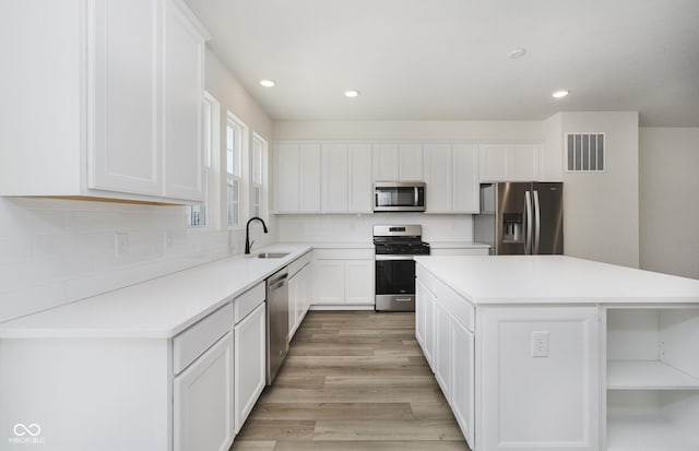 14514 Hanford Ln, Carmel, IN 46074 - kitchen with appliances with stainless steel finishes, a center island, white cabinetry, tasteful backsplash, and recessed lighting