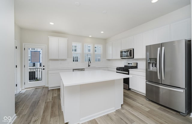 14514 Hanford Ln, Carmel, IN 46074 - kitchen featuring appliances with stainless steel finishes, tasteful backsplash, a kitchen island, light wood finished floors, and recessed lighting