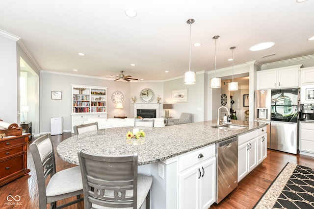 13427 Merryvale St, Fishers, IN 46037 - kitchen featuring stainless steel appliances, ceiling fan, crown molding, open floor plan, and a fireplace