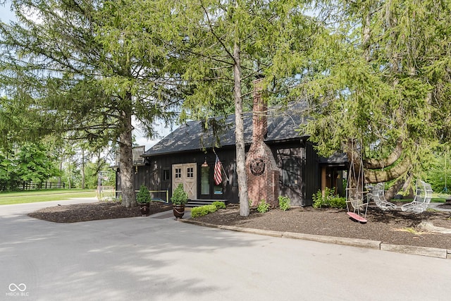 1616 W 116th St, Carmel, IN 46032 - view of front of home with board and batten siding and a chimney