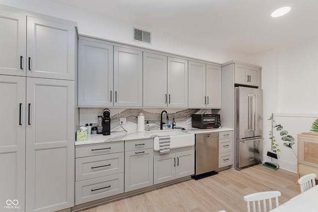 1616 W 116th St, Carmel, IN 46032 - kitchen with appliances with stainless steel finishes, gray cabinetry, and light wood finished floors