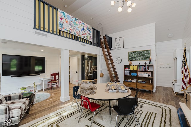 1616 W 116th St, Carmel, IN 46032 - dining area with wood-type flooring, a chandelier, wooden walls, and a high ceiling