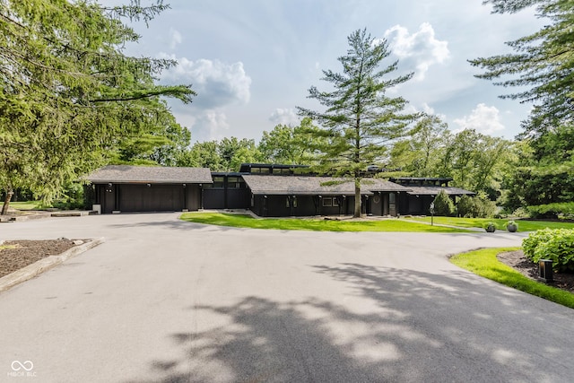 1616 W 116th St, Carmel, IN 46032 - view of front of house with curved driveway, a garage, view of scattered trees, and a front yard