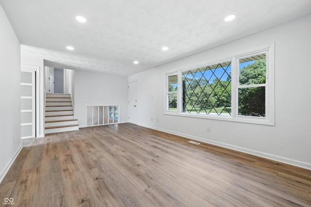 1011 Robin Dr, Anderson, IN 46013 - unfurnished living room with recessed lighting, wood finished floors, and stairs