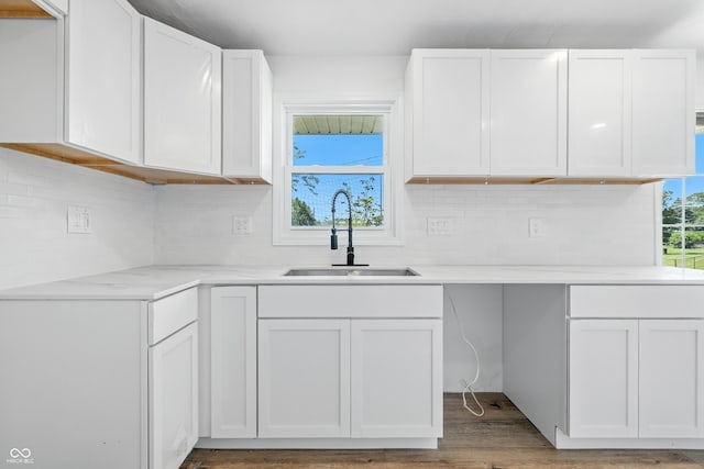 1011 Robin Dr, Anderson, IN 46013 - kitchen featuring backsplash, white cabinetry, and wood finished floors