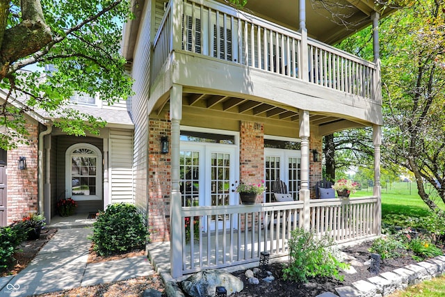 6298 Briargate Dr, Zionsville, IN 46077 - view of exterior entry featuring a balcony, brick siding, and french doors