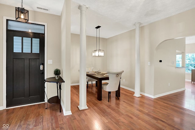6298 Briargate Dr, Zionsville, IN 46077 - entrance foyer featuring decorative columns, wood finished floors, and a textured ceiling