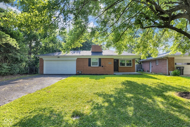 1231 N Graham Ave, Indianapolis, IN 46219 - view of front of house featuring brick siding, an attached garage, a front yard, a chimney, and asphalt driveway