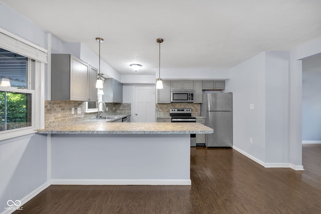 1231 N Graham Ave, Indianapolis, IN 46219 - kitchen featuring stainless steel appliances, gray cabinetry, tasteful backsplash, light countertops, and healthy amount of natural light