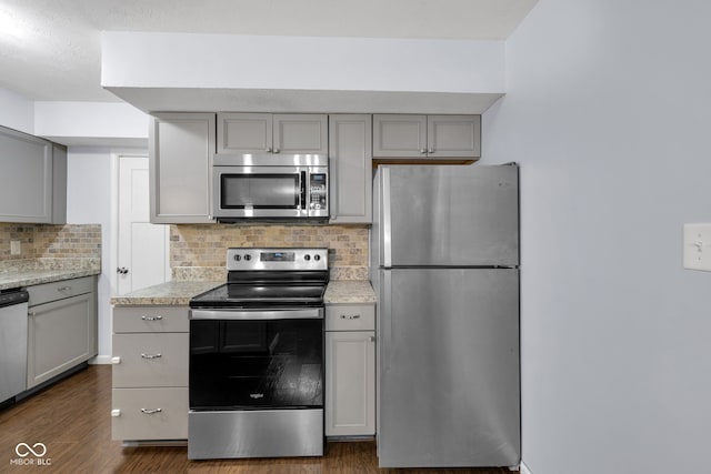 1231 N Graham Ave, Indianapolis, IN 46219 - kitchen featuring stainless steel appliances, gray cabinets, tasteful backsplash, and dark wood finished floors