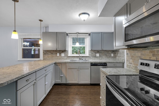 1231 N Graham Ave, Indianapolis, IN 46219 - kitchen featuring appliances with stainless steel finishes, dark wood-style flooring, decorative backsplash, and gray cabinetry