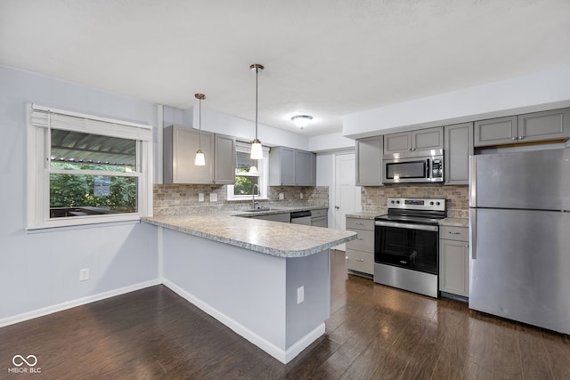 1231 N Graham Ave, Indianapolis, IN 46219 - kitchen with stainless steel appliances, gray cabinetry, light countertops, decorative backsplash, and a peninsula