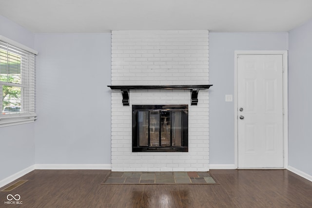 1231 N Graham Ave, Indianapolis, IN 46219 - unfurnished living room with a brick fireplace and wood finished floors