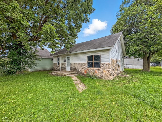 356 S 7th St, Frankfort, IN 46041 - back of property featuring stone siding, a lawn, and roof with shingles